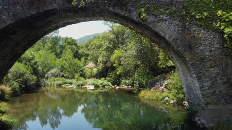 flight over the sil river and under an ancient roman bridge in rural spain