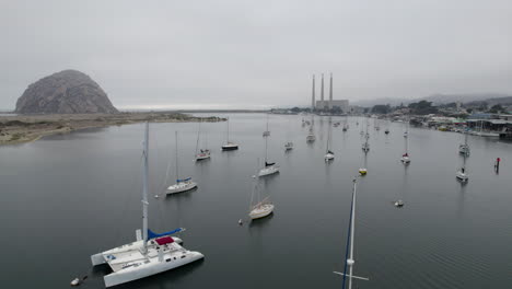 aerial flying over moored boats in marina in morro bay on overcast day