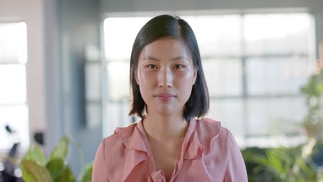 Retrato-De-Una-Feliz-Y-Casual-Mujer-De-Negocios-Asiática-En-La-Oficina,-Sonriendo-En-Cámara-Lenta
