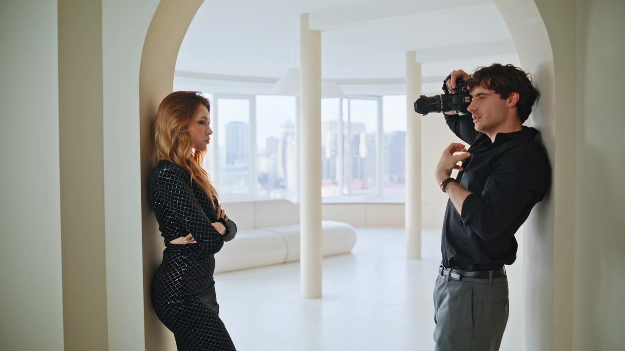 Photographer shooting elegant model penthouse. Fashion photoshoot backstage.