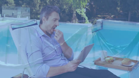 relaxing by pool, man reading newspaper with breakfast tray beside him