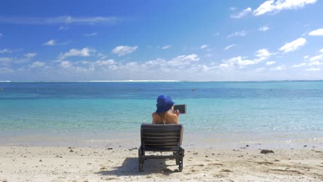 Frau-Mit-Pad-Beim-Sonnenbaden-An-Der-Küste-Der-Blauen-Lagune