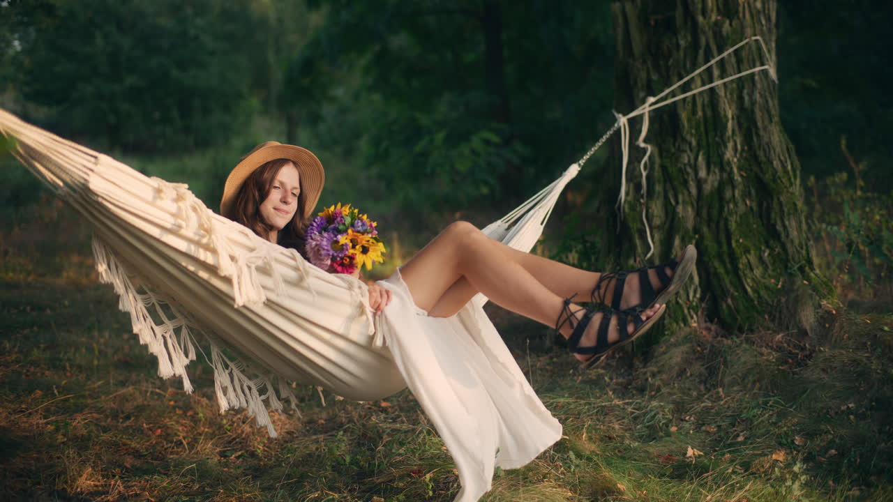 Girl enjoys calm sunset in forest hammock