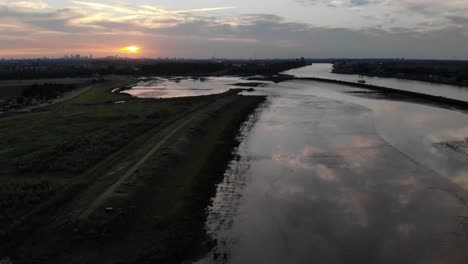 reflection of clouds during sunset at a fresh water tidal area in the netherlands