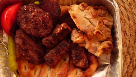 grilled chicken and köfte in a disposable container