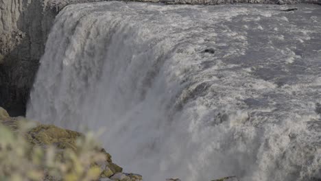 rushing waters of an icelandic waterfall over basalt cliffs