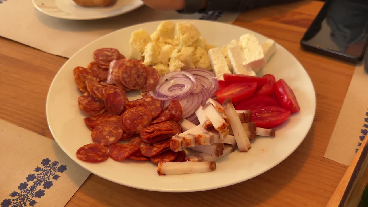 Plato tradicional de aperitivo con fiambres, queso y verduras frescas