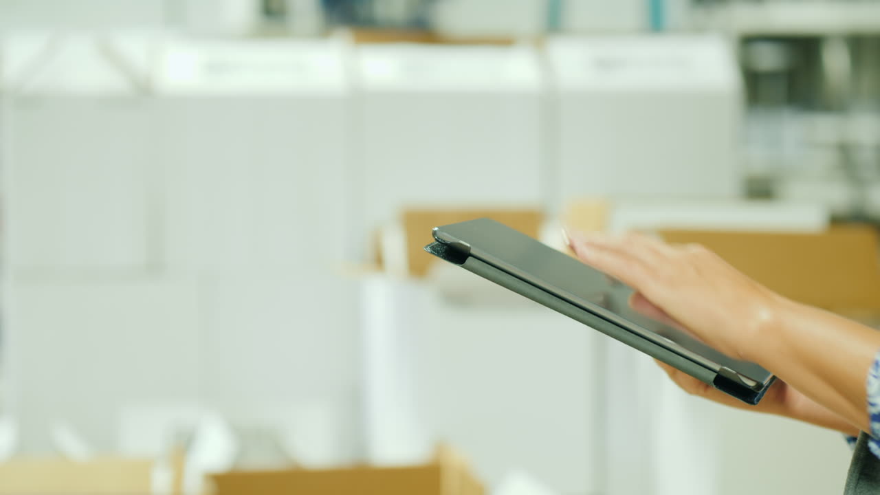manos de mujer usando tableta por cajas blancas