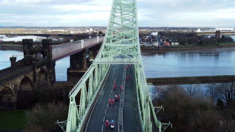 charity santa dash fun run over runcorn silver jubilee bridge aerial view zooming in close