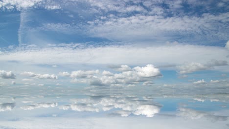 futuristic background consisting of time lapse clip of white fluffy clouds over blue sky and their reflection, video loop