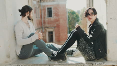 overcome the crisis in the relationship young man and woman hold hands sit on a windowsill in an aba