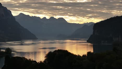 vista panorámica del lago walensee al atardecer, donde las nubes esponjosas se reflejan hermosamente en las aguas tranquilas