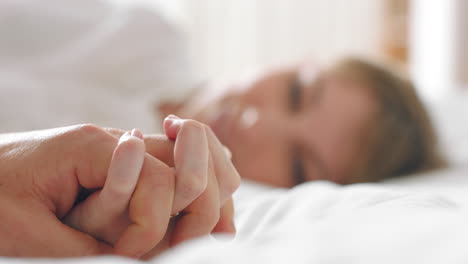 couple holding hands in bed