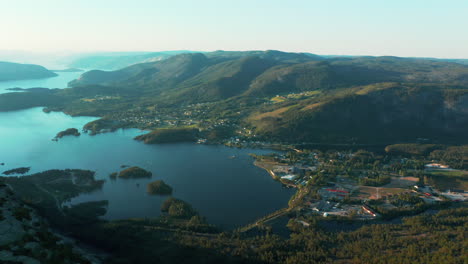 cinematic aerial of treungen village on lake nisser by green mountains, norway
