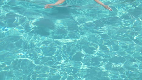 mujer nadando en una piscina en un día soleado