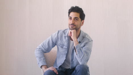 handsome man in a denim shirt smiles at camera