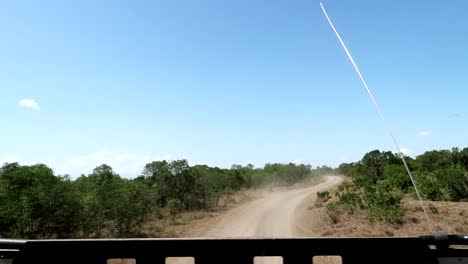 在沙法里尘土飞扬的道路上,一辆4x4车的后面.