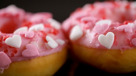 heart shaped sprinkled pink donuts. sliding shot