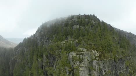 Vista-Panorámica-En-La-Cima-De-La-Montaña-Skyrim-En-Noruega-Rodeada-De-Exuberantes-árboles-Verdes---Toma-Aérea