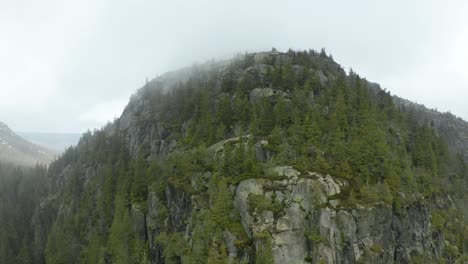 Scenic-View-At-The-Peak-Of-Skyrim-Mountain-In-Norway-Surrounded-With-Lush-Green-Trees---Aerial-Shot