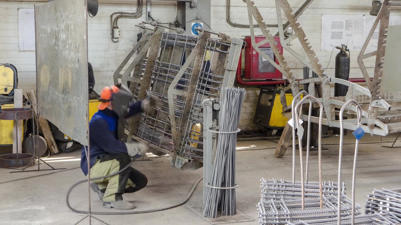 Soldador trabajando con electrodo en soldadura por arco semiautomática en planta de producción manufacturera, timelapse