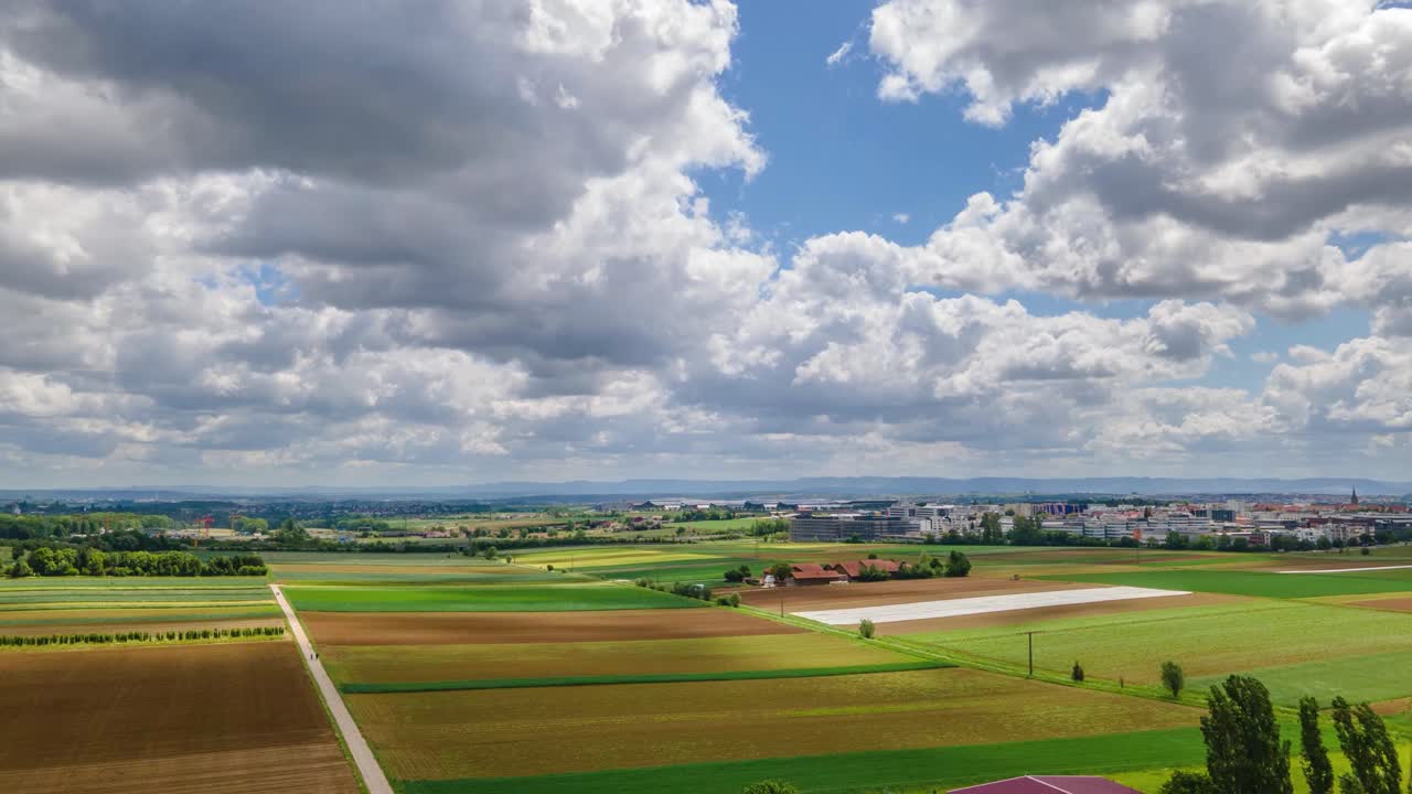 Luchthyperlapse met veel wolken op een zonnige dag boven groene velden in 4K