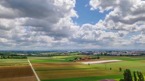 aerial hyperlapse with many clouds at sunny day over green fields in 4k