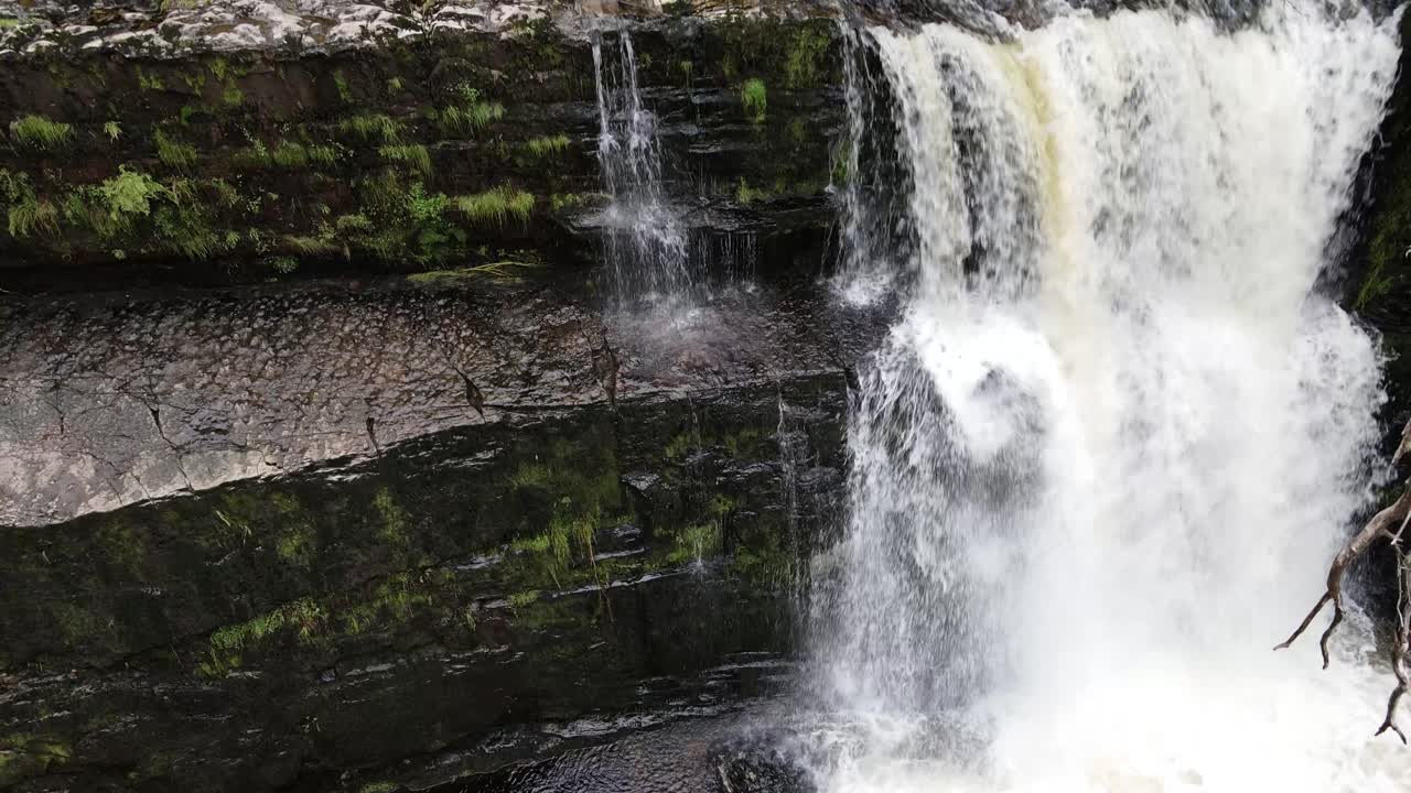 Cascading fresh rocky woodland waterfall tranquil scene in idyllic Breacon Beacons rising aerial