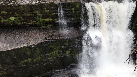 cascading fresh rocky woodland waterfall tranquil scene in idyllic breacon beacons rising aerial