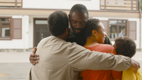 male soldier hugging and saying goodbye to his family outside home before going for military service 1