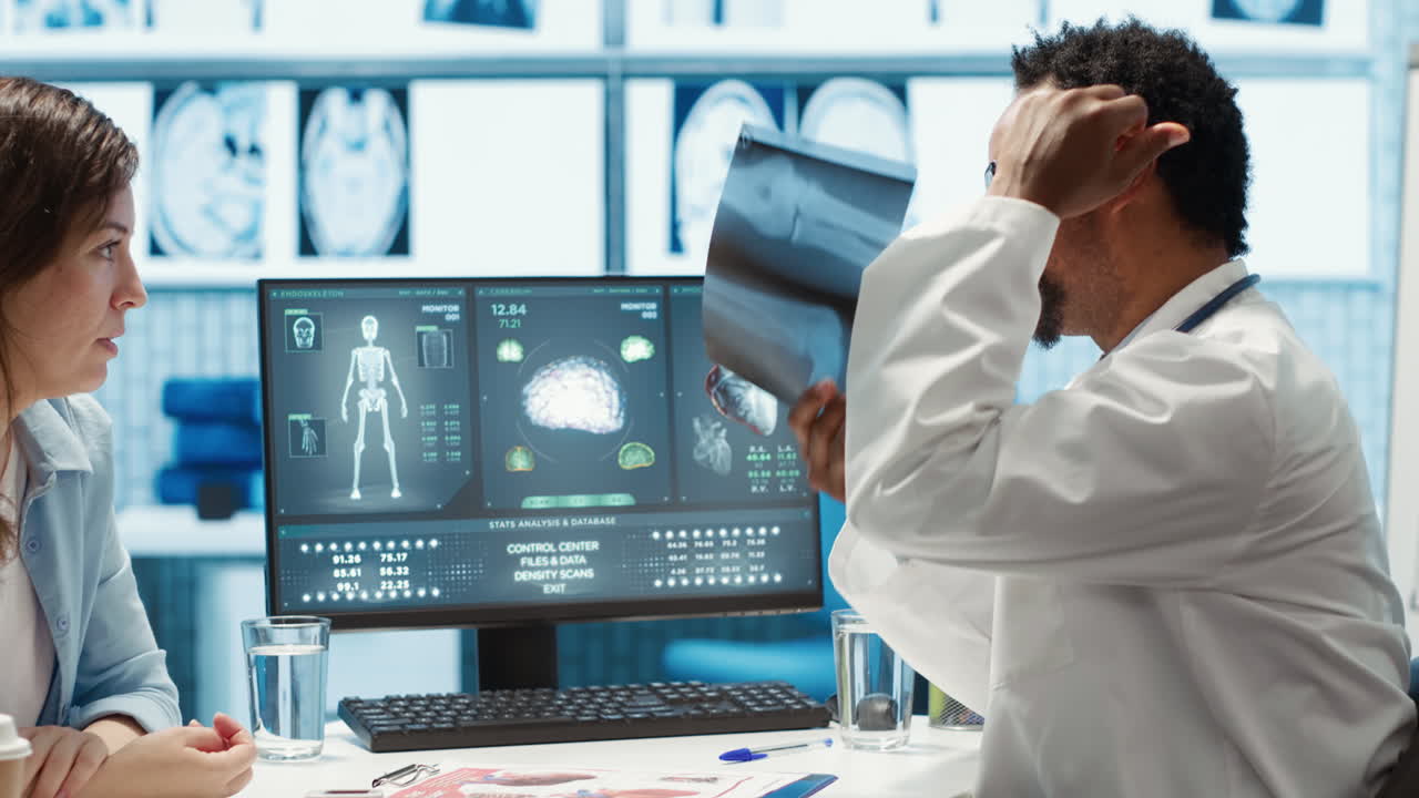 médico afroamericano presentando los resultados de los diagnósticos de rayos x a un paciente