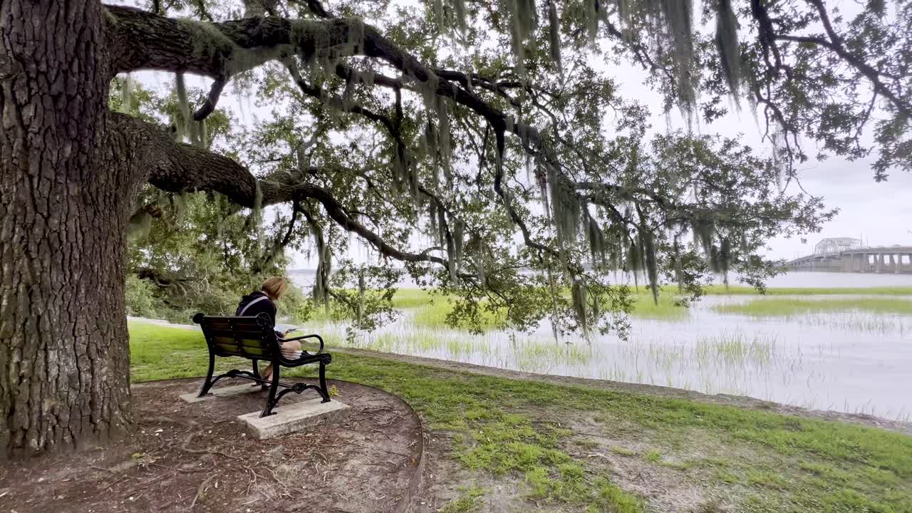 Girl sits under live oak tree in Beaufort SC, South Carolina