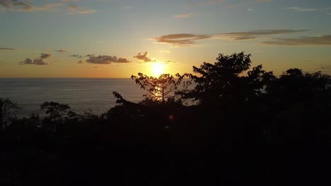 una toma aérea de la fabulosa puesta de sol de la playa de uvita en costa rica, una lenta panorámica a la derecha: un magnífico sol naranja proyectando su resplandor sobre el mar, una vibrante belleza natural mientras nadie está alrededor