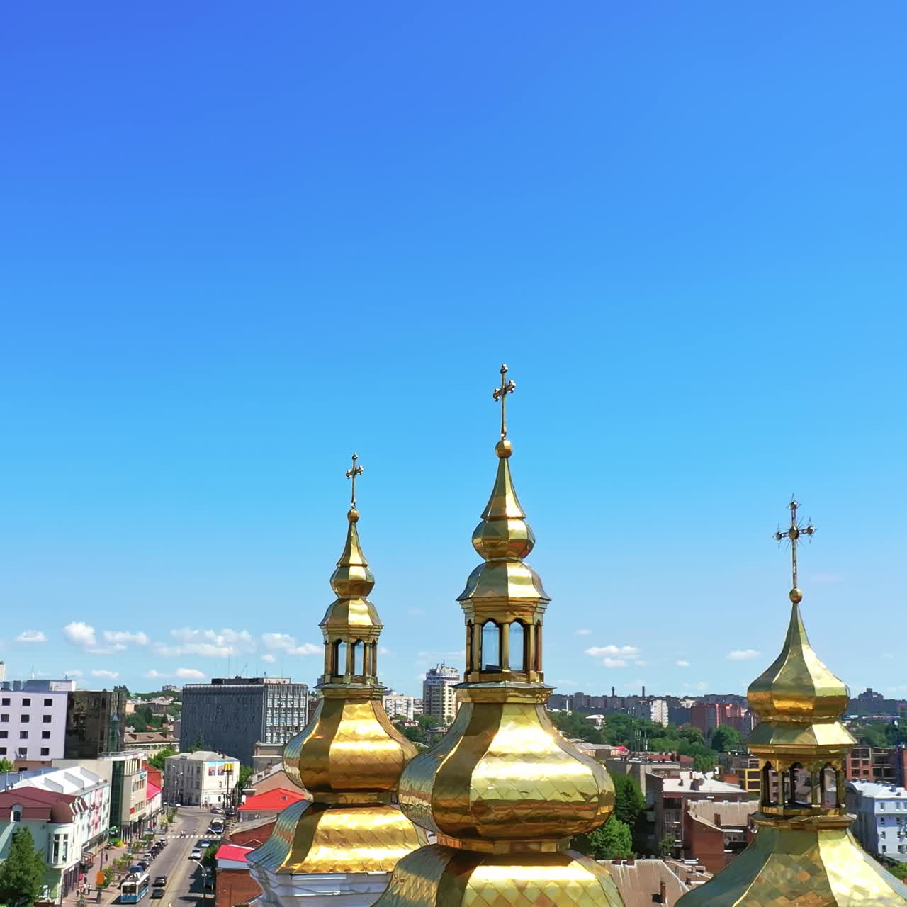 City view with beautiful cathedral in the centre. Golden cupolas with crosses at backdrop of blue clear sky