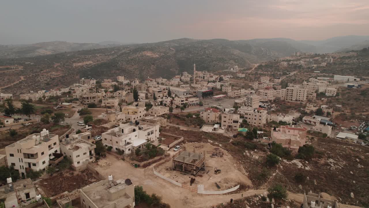 Vista aerea panoramica posteriore di un villaggio tra le montagne in Israele, drone che vola sopra le case