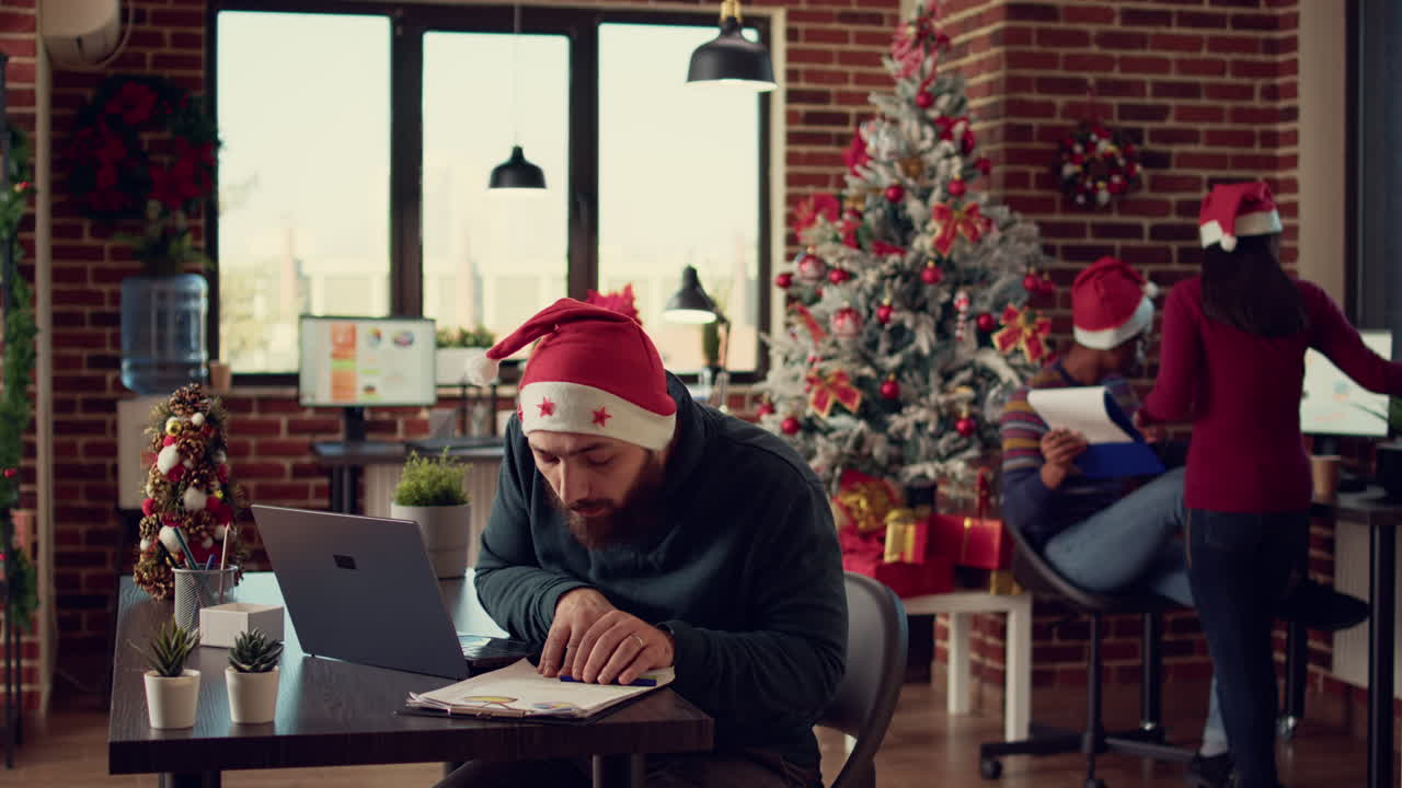 Project manager working on laptop in festive office