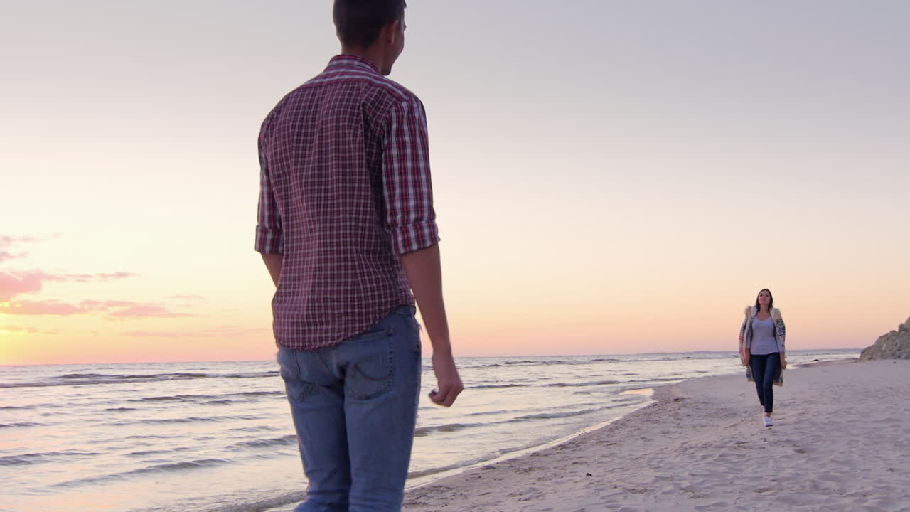 una pareja joven se conoció en la playa abrazándose