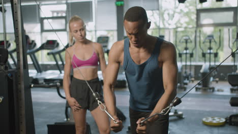 front view of caucasian female monitor and an athletic african american man in the gym.