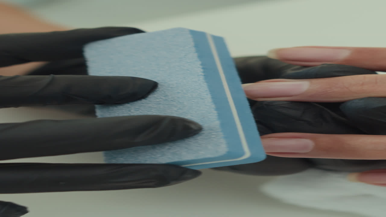 Vertical of Manicurist Using File on Nails of Client