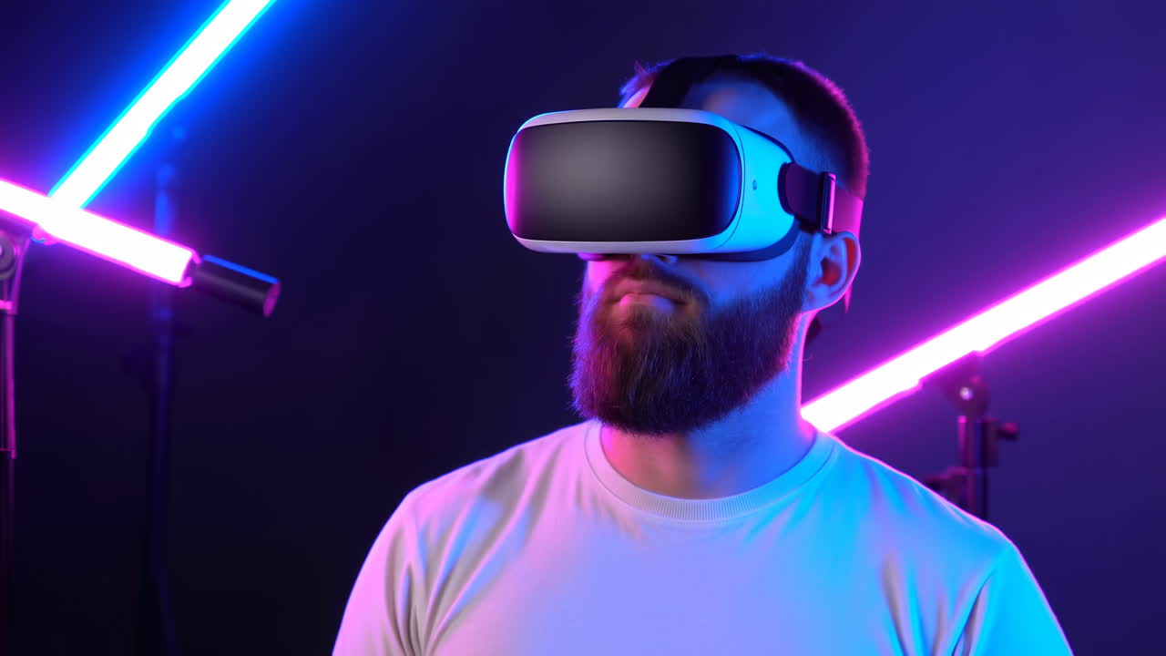 Uomo caucasico con visore di realtà virtuale in uno studio illuminato al neon, soggetto barbuto che guarda in alto.