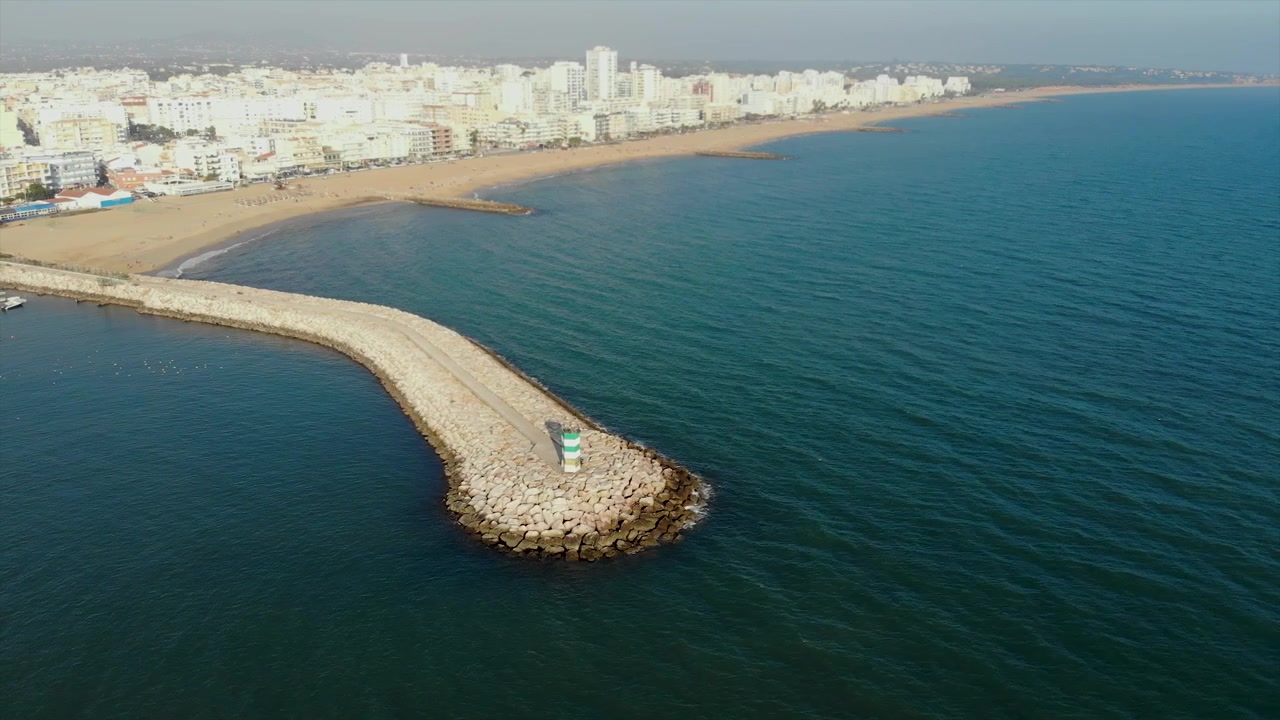 Faro e porto nella città di Quarteira al tramonto