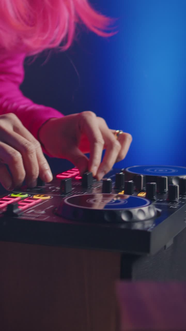 Video verticale: musicista in piedi alla console da DJ mentre suona un brano di musica elettronica