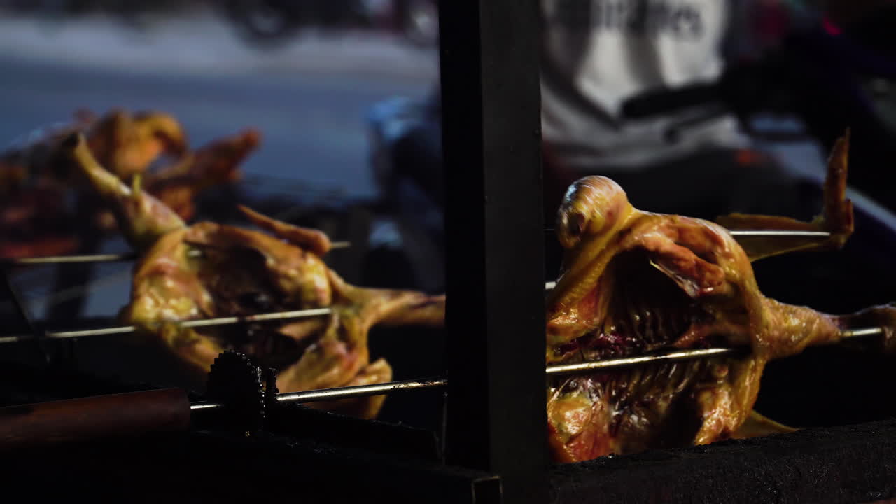 거리 옆 바비큐 그릴 위에서 회전하는 꼬챙이에 오리 통째로 굽기