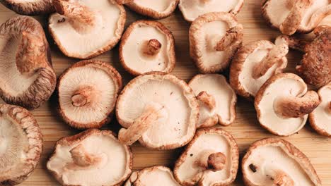 freshly sliced shiitake mushrooms on a wooden cutting board