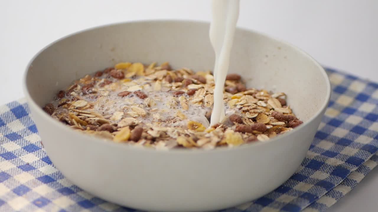 movimiento lento de la leche vertiendo en un granola musli en un tazón