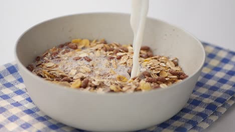 Slow-motion-of-milk-pouring-in-a-granola-musli-in-a-bowl