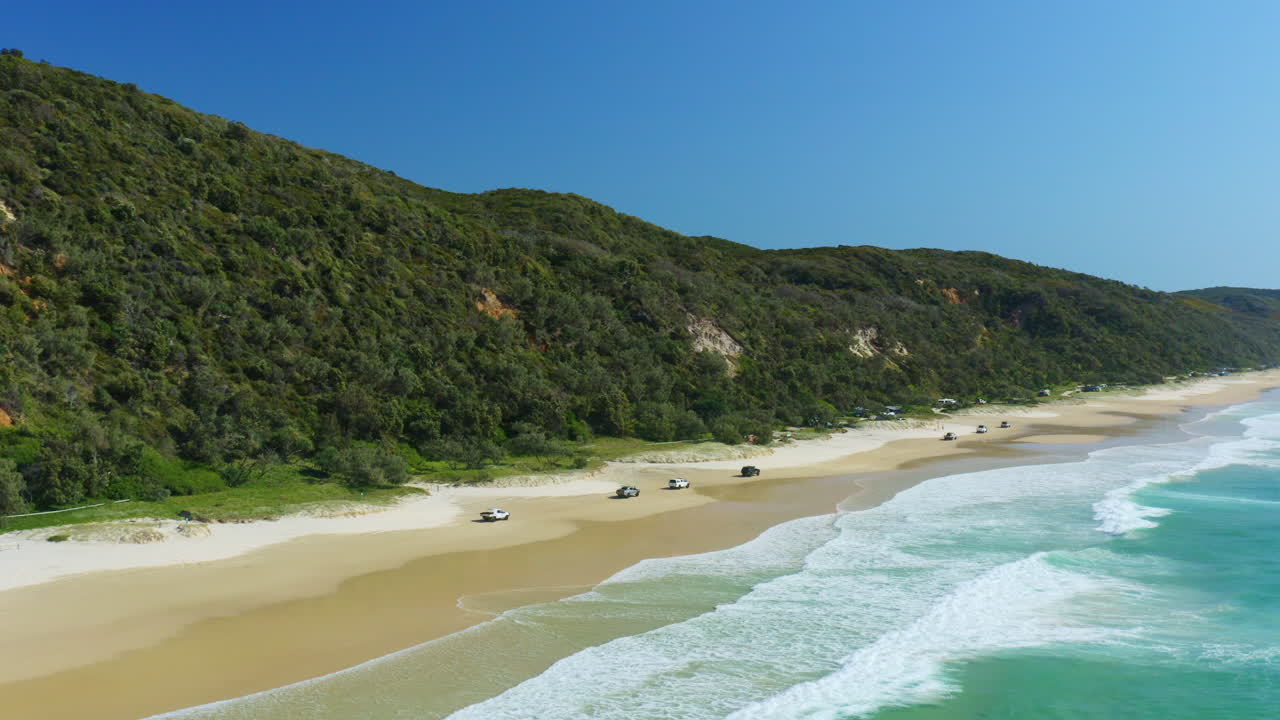 convoy de autos 4wding a lo largo de la hermosa playa australiana hasta el campamento, australia, drone aéreo 4k
