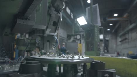 Wide-angle-view-of-a-metal-milling-machine-in-operation-at-a-factory,-carving-through-a-sheet-of-steel-with-metal-fragments-scattering-in-all-directions-with-the-factory-interior-in-the-background