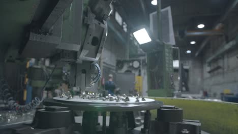 wide-angle view of a metal milling machine in operation at a factory, carving through a sheet of steel with metal fragments scattering in all directions with the factory interior in the background