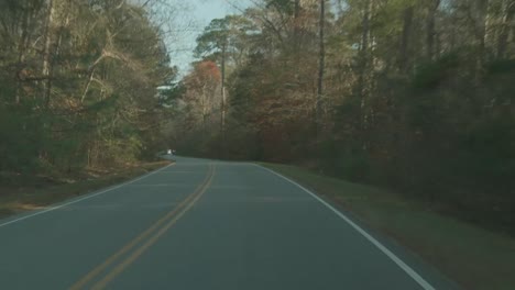 Conduciendo-Por-Una-Carretera-Curva-De-Dos-Carriles-A-Través-De-Los-árboles-De-Otoño